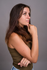 Portrait of young beautiful woman against gray background