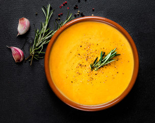 Pumpkin and carrot  Cream soup on  black board  background. Autumn cream-soup in country style. Top view. Copy space.