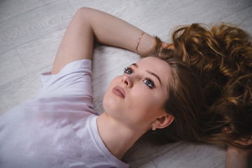 Fototapeta premium Girl in a white t-shirt lying on the floor