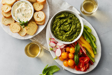 Top view Vegetable snacks with pesto sauce flat lya