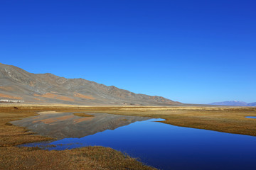 Reflection of lake after beautiful mountain with blue sky of Western Mongolia. Natural background	
