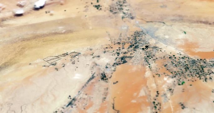 Very high-altitude circular tracking shot of Arabian Desert farms with tilt-shift effect. Reversible. Elements of this image furnished by NASA. 