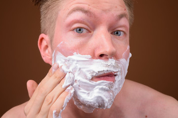 Face of young man shaving his face