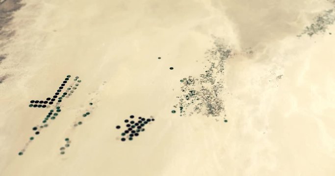 Very high-altitude circular tracking shot of desert farms in Libya with tilt-shift effect. Reversible. Elements of this image furnished by NASA. 
