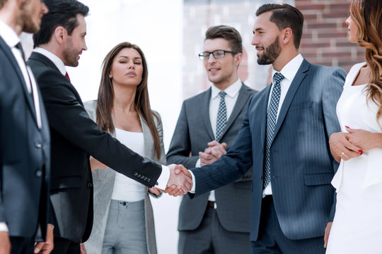 business team looks at the handshake of business partners