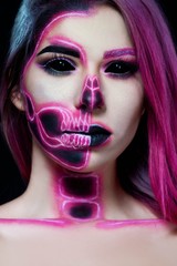 Halloween. Woman in day of the dead mask skull face art. Pink and black skull make up.
