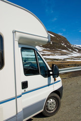Motorhome / RV at the side of the road in Norway with snowy hills in the background