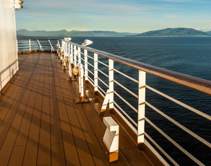 Obraz premium Cruise ship Port deck and railing in late afternoon, Inside Passage, BC, Canada.