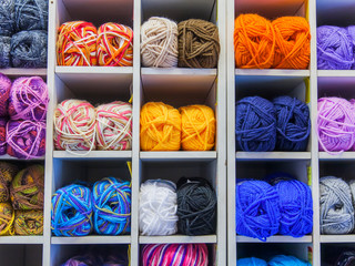 Hanks of multi-colored woolen threads for needlework on a show-window in shop