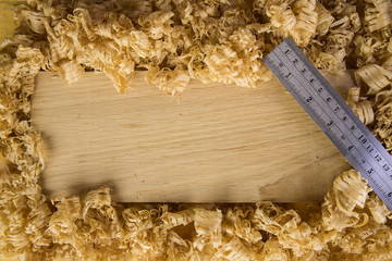 Ruler on top of an oak board covered with wood shavings