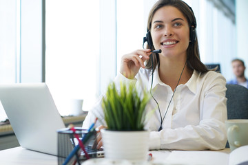 Woman customer support operator with headset and smiling.