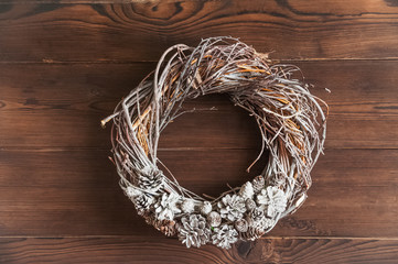 Textural Christmas wreath of twigs and cones on a dark wooden background. The concept of Christmas, New Year.