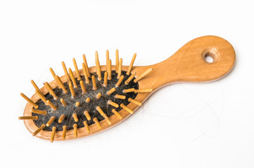 Wooden comb brush with lost hair - baldness concept