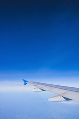 Fototapeta na wymiar top view blue sky with wing of airplane