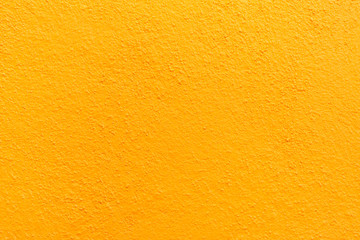 Naklejka premium Stucco wall - Yellow stucco textured wall background with natural light.