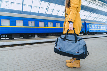 woman hold bag on railway station. watch on wrist.