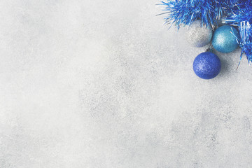 Blue Christmas balls and tinsel on grey background. New Year concept and scenery Copy space