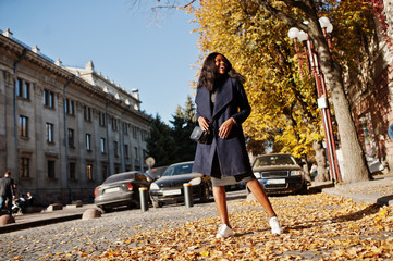 Stylish african american girl in blue coat posed at sunny autumn day. Africa model woman.