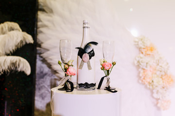 Wedding background of white decorated champagne bottle and glasses