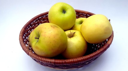 cinq pommes vertes dans une corbeille sur fond blanc