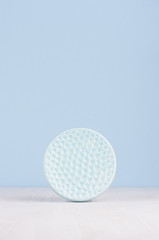 Elegant modern home decor of decorative smooth ceramic circle ribbed dish on white wood table.