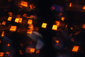DJ mixer in a nightclub with a background of glowing lights from buttons and controllers