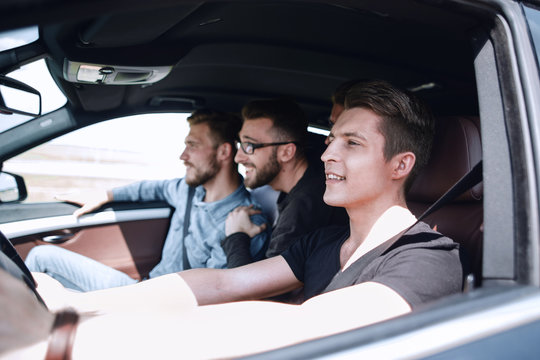 a group of boys rides and looks directly at the car