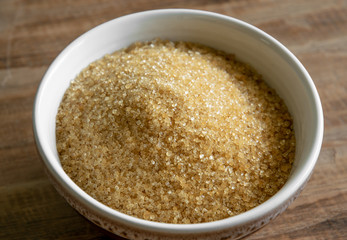 brown sugar in a bowl on wooden table background