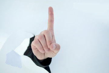 close up.businessman showing his index finger through the torn p