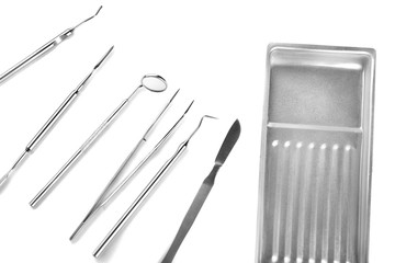 Dentist's tools and metal tray on white background
