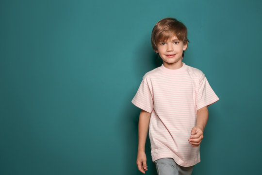 Little boy in t-shirt on color background
