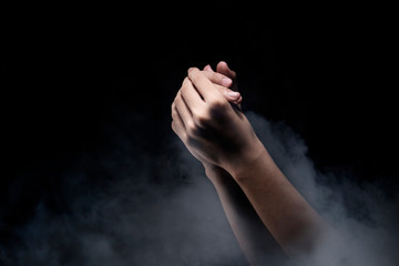 Fototapeta na wymiar Praying hands over dark background