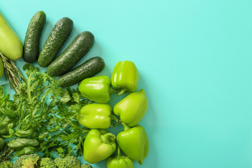Flat lay composition with fresh vegetables and herbs on color background