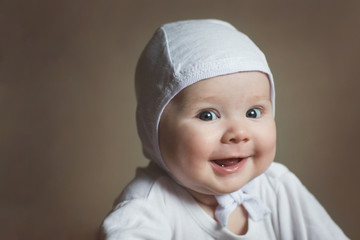 portrait of a baby in a white cap close-up. happy child
