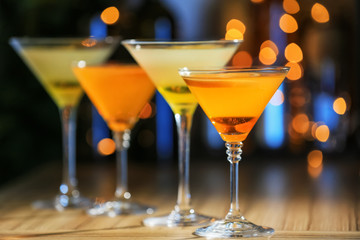 Fresh summer cocktails in glasses on table against blurred lights