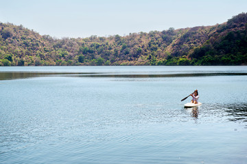 Portrait of asian woman paddling a kayak on the lake in satonda island