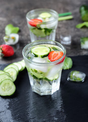 Glass of fresh cucumber water on slate plate