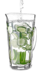 Pouring of fresh cucumber water into jug on white background