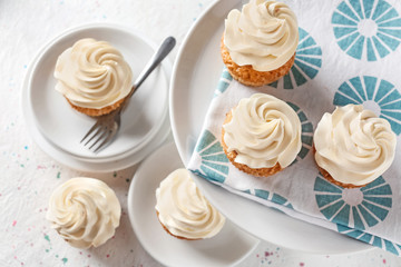 Plates with delicious cupcakes on light table