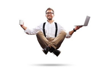 Young man is soaring in the air with a Cup of coffee and a laptop