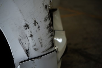 close up of damaged scratching on the front of the white car