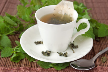 Geen tea in cup with mint leaves, herbal tea concept