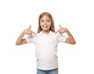 Little girl pointing at her t-shirt on white background