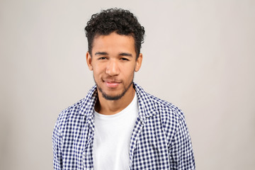 Portrait of handsome African-American man on light background