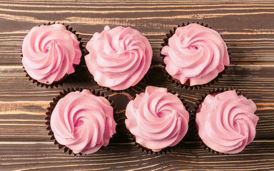 Sweet cupcakes on wooden table, top view