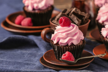 Plate with sweet cupcake on table
