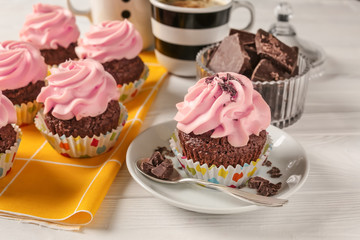 Sweet cupcakes with chocolate on wooden table