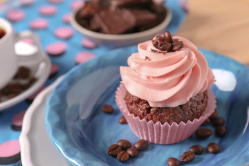 Plate with sweet cupcake and coffee beans, closeup