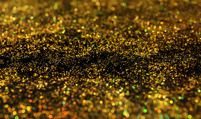 Shiny gold glitter on dark background