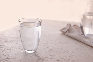 Glass of cold water on white table